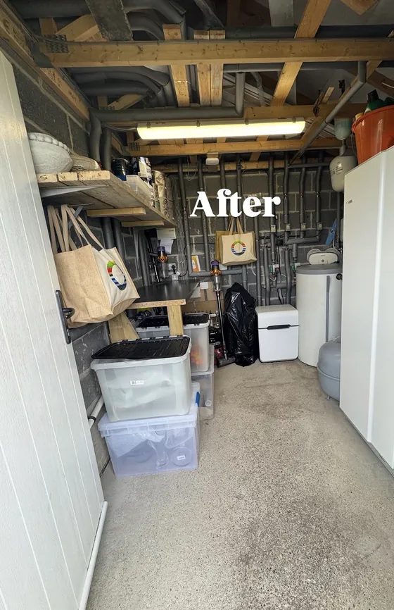The same garage after: clear floor, labelled boxes stacked neatly and the walkway open
