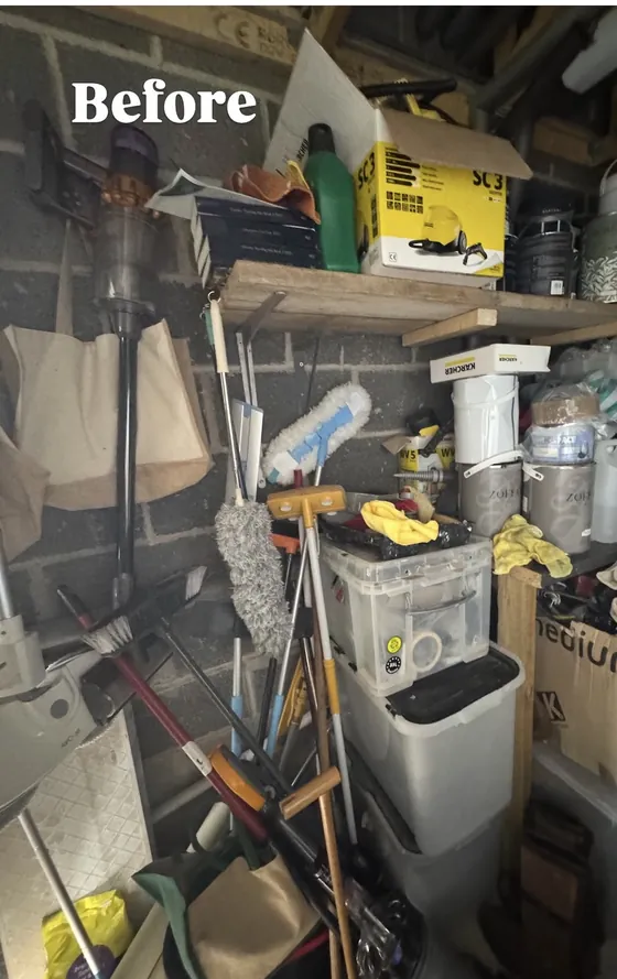 A garage corner before: shelves and floor stacked with tools, boxes, paint tins and cleaning gear